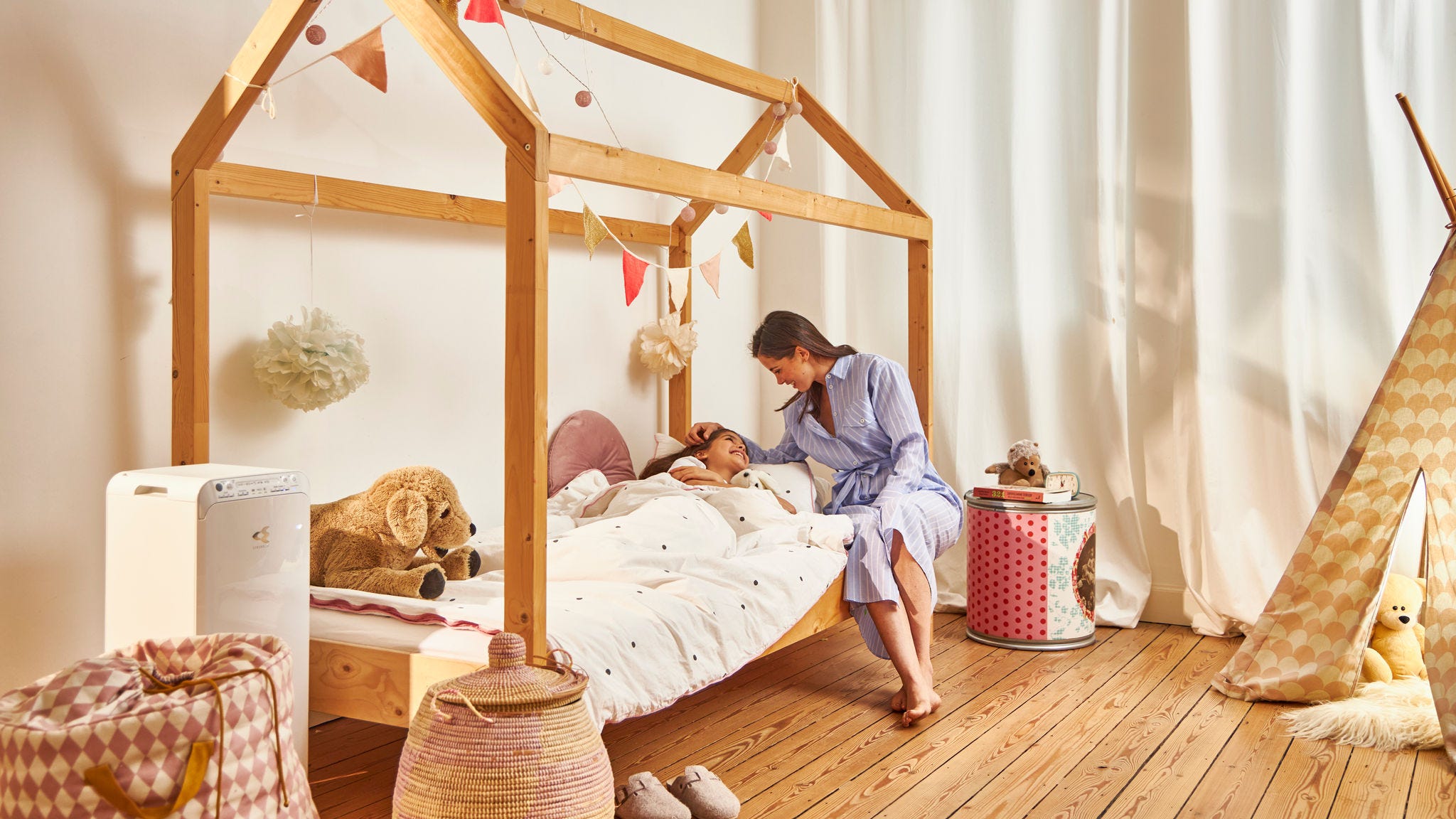 En mamma som nattar sitt barn i deras hälsosamma hem, tack vare luftrenaren från Daikin i barnrummet