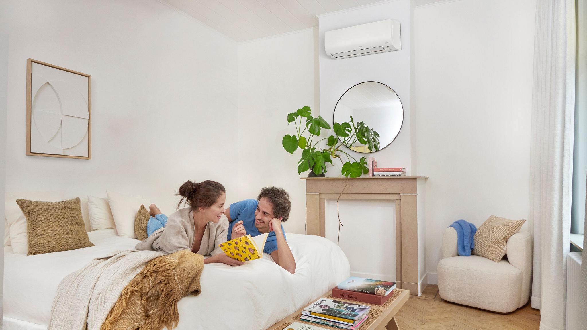 En kvinna som sitter i vardagsrummet med komprtabel temperatur tack vare Daikins luft/luftvärmepumpar