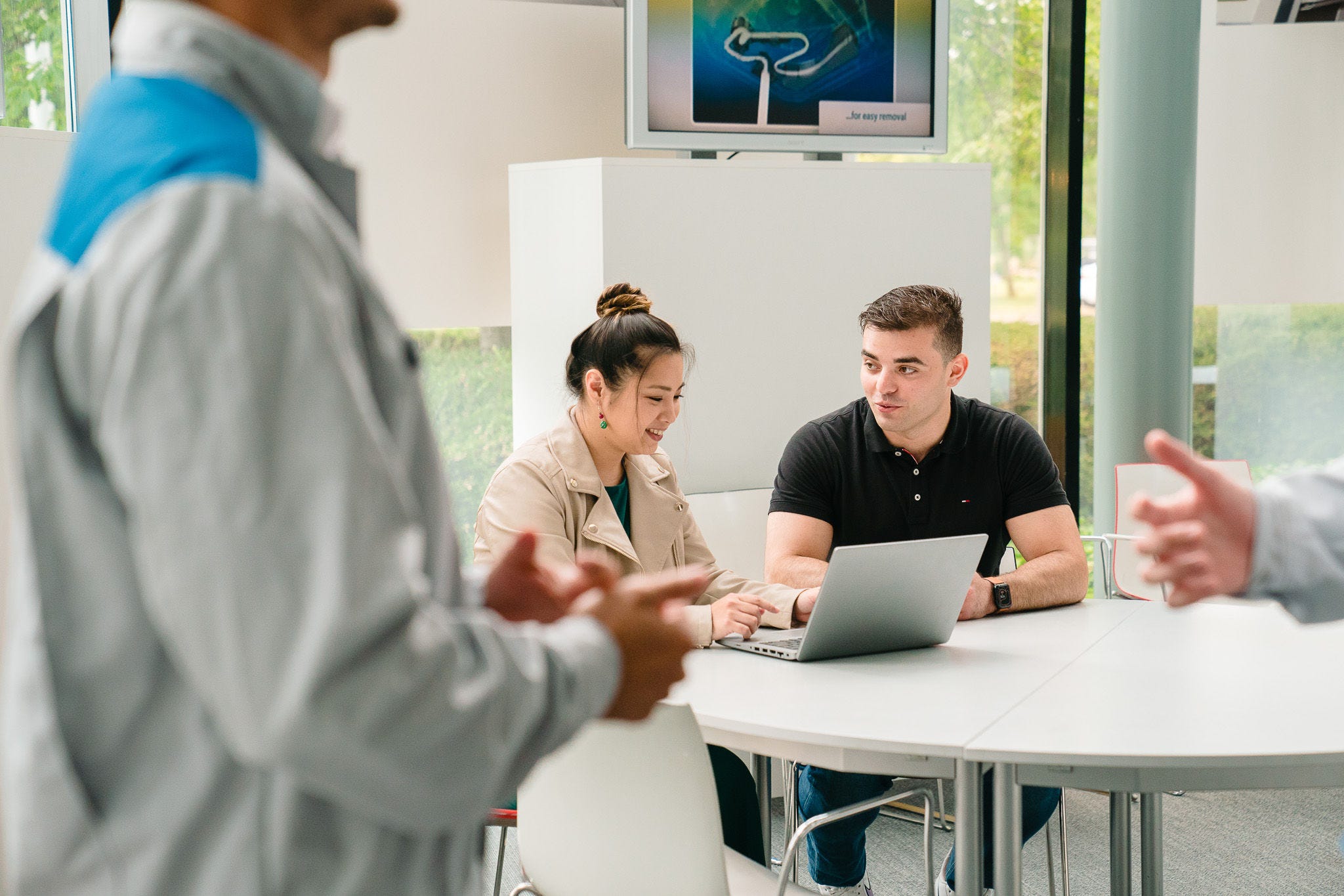 En kvinna som förklarar något på den bärbara datorn för en man