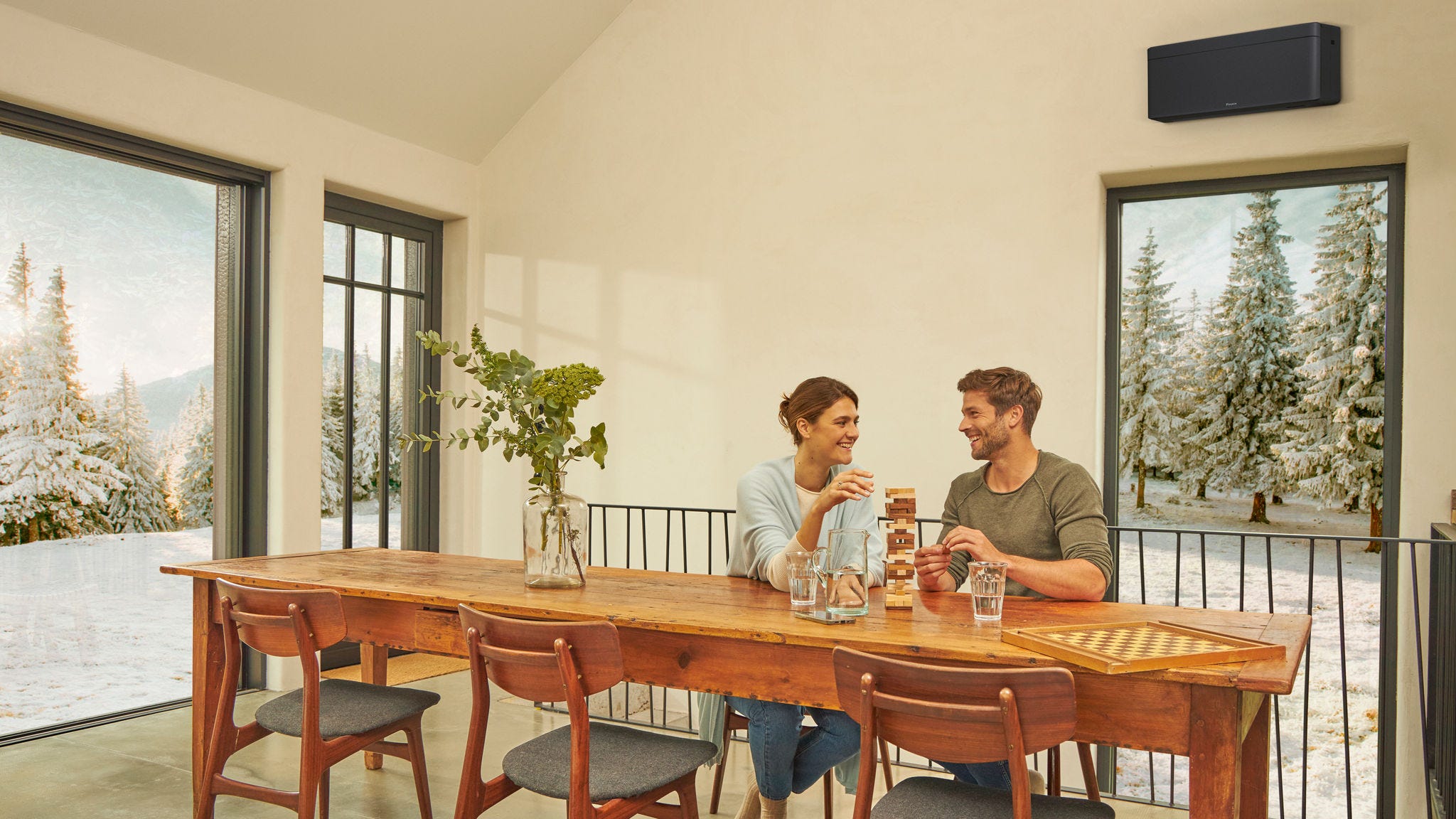 Ett par njuter av behaglig värme från en luftkonditioneringsenhet i vardagsrummet