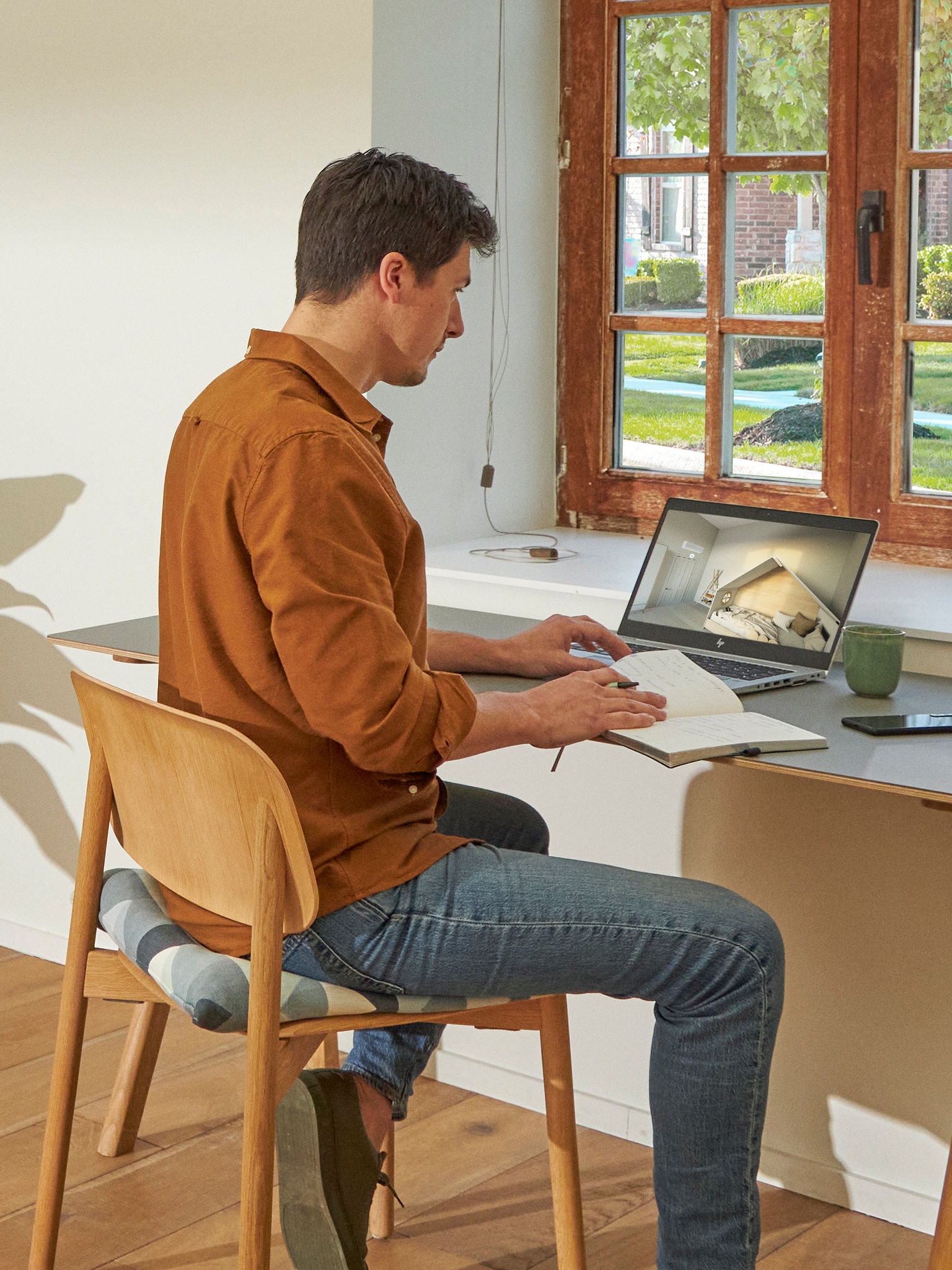 Man som sitter vid sitt skrivbord och tittar på luftkonditioneringar i Daikins virtuella experience centre på sin bärbara dator