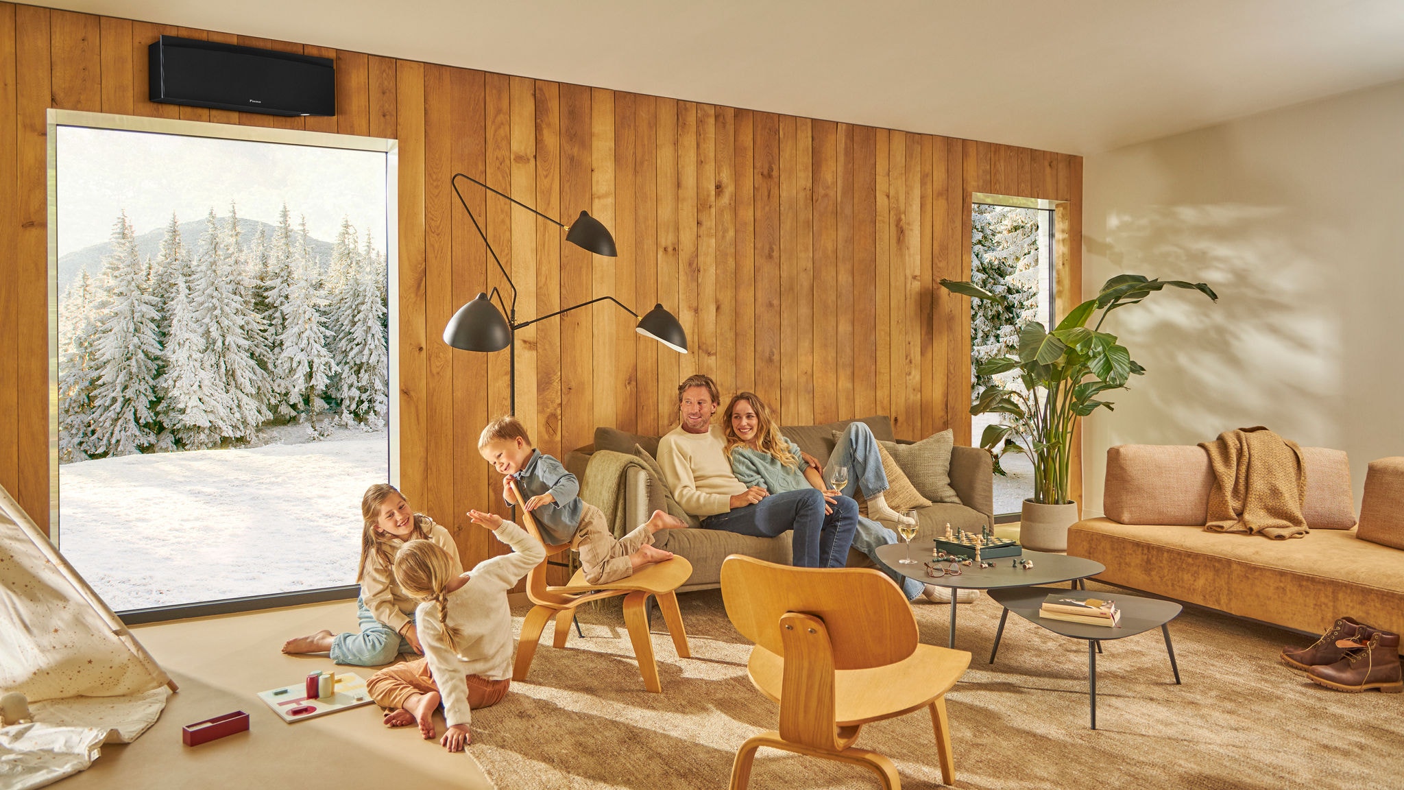 En familj som spelar brädspel i sitt vardagsrum som värms upp av en Daikin Stylish luftvärmepump.
