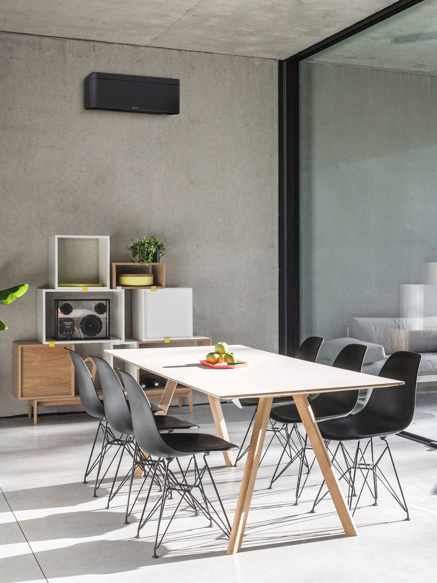 Ett matrum med ett stort fönster och en installerad väggmonterad luft/luftvärmepump