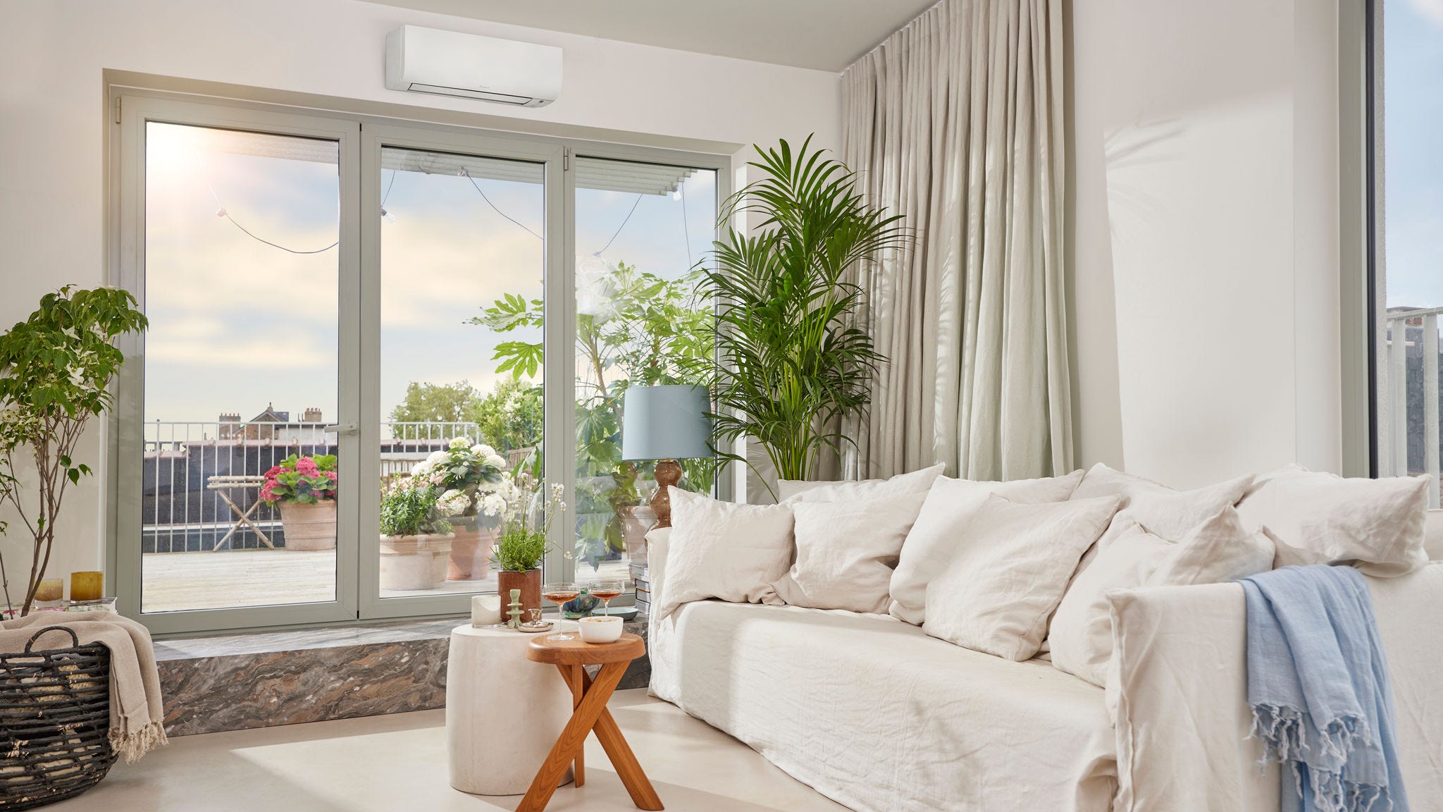 Ett ljust och luftigt rum med en diskret vit, väggmonterad luft/luftvärmepump som ger både värme och kyla