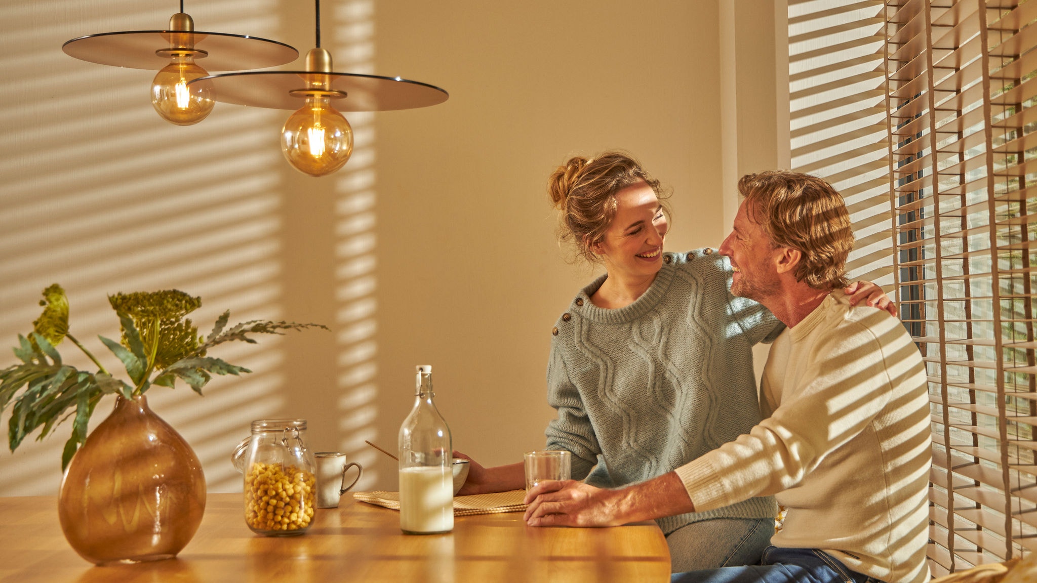 Ett par som njuter av en mysig frukost tillsammans i sitt komfortabla varma kök, tack vare denna intuitiva uppvärmningsteknik