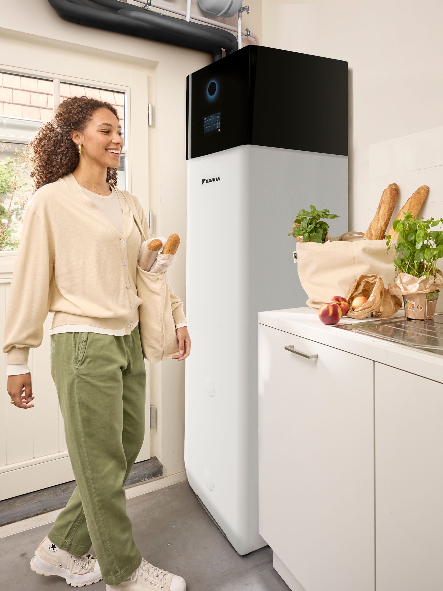 Kvinna som kommer hem från shopping och bär matkassar