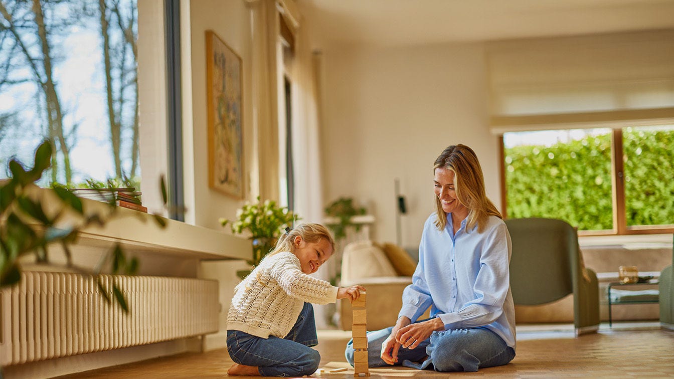 Mamma leker med sin dotter i skönt inomhusklimat med en Daikin luftvärmepump