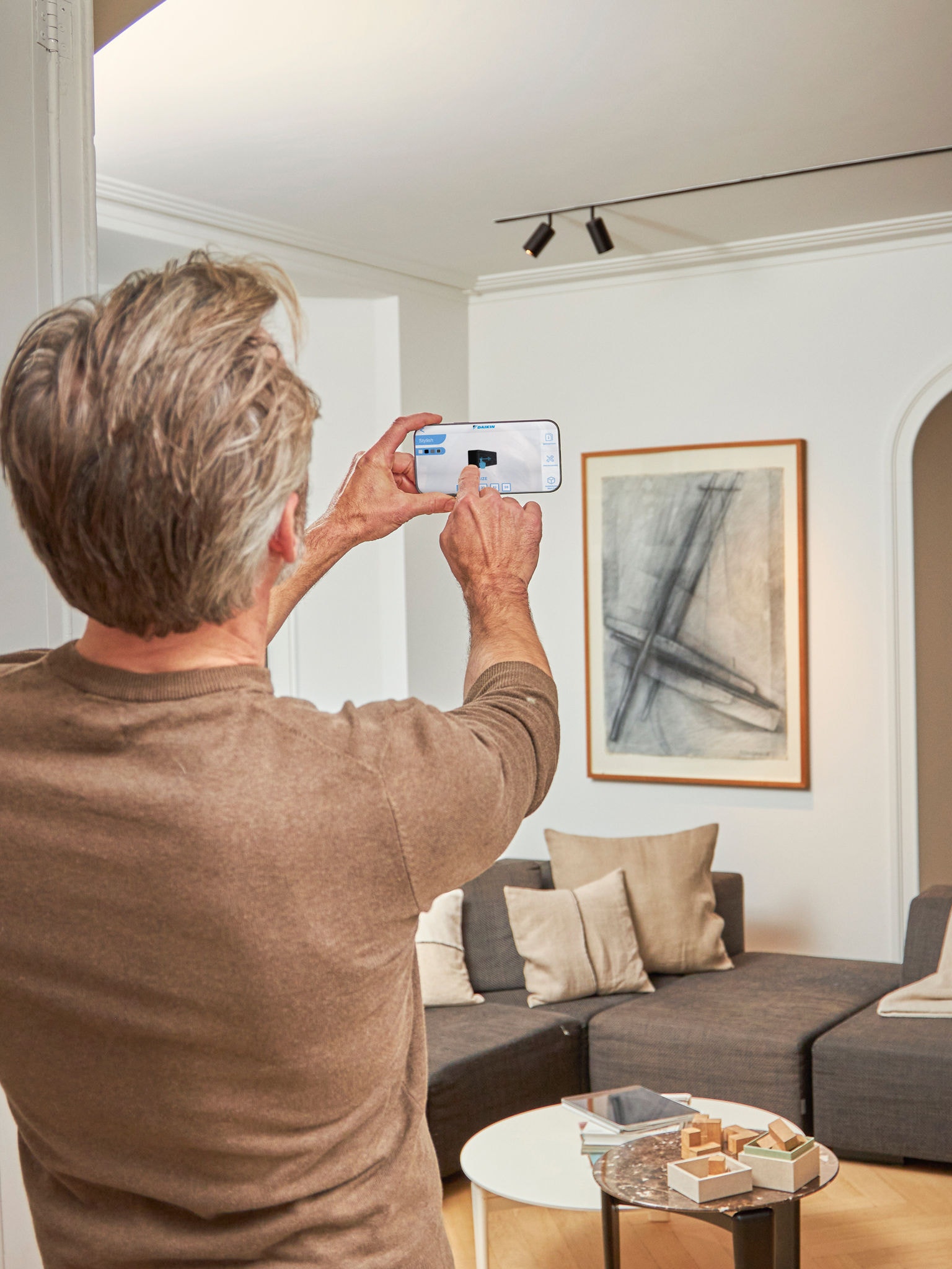 Man som använder 3D-appen med luft/luftvärmepumpar i förstärkt verklighet, för att visualisera enheterna i miljön inomhus och utomhus