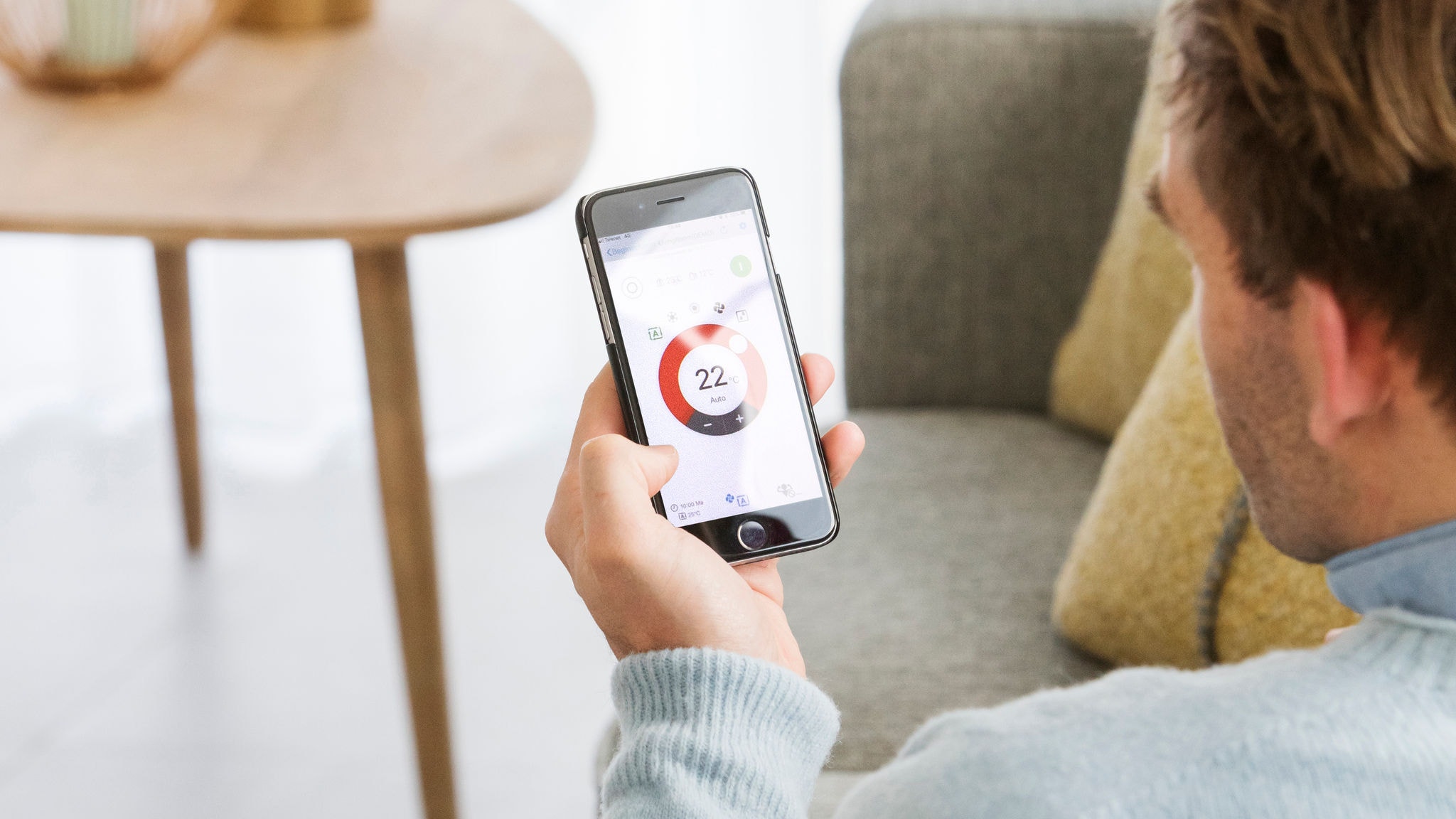 Man som styr temperaturen i sitt vardagsrum via appen Onecta
