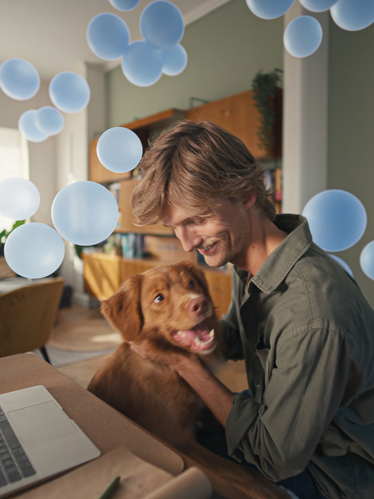 Ung man vid sitt skrivbord med sin hund som njuter av tyst komfort och smart klimatkontroll