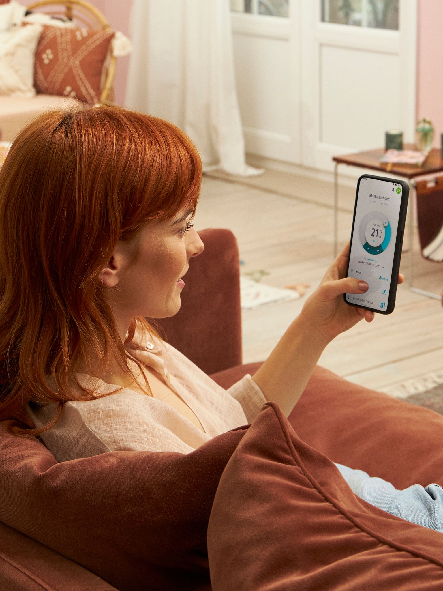Kvinna som styr varje inomhusenhet separat med Onecta-appen