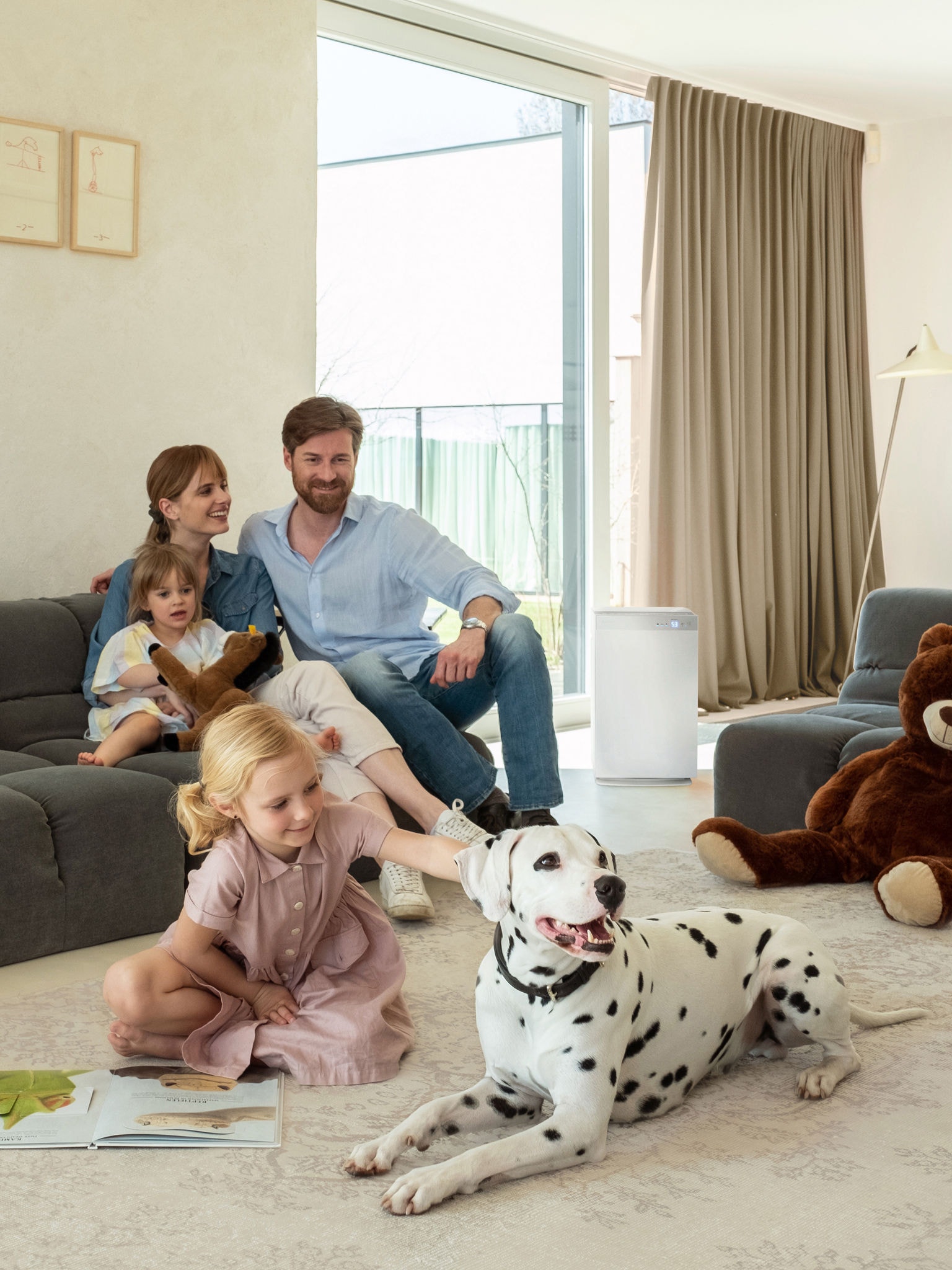 Family with two kids and a Dalmatian dog relaxing in the living room in good air quality