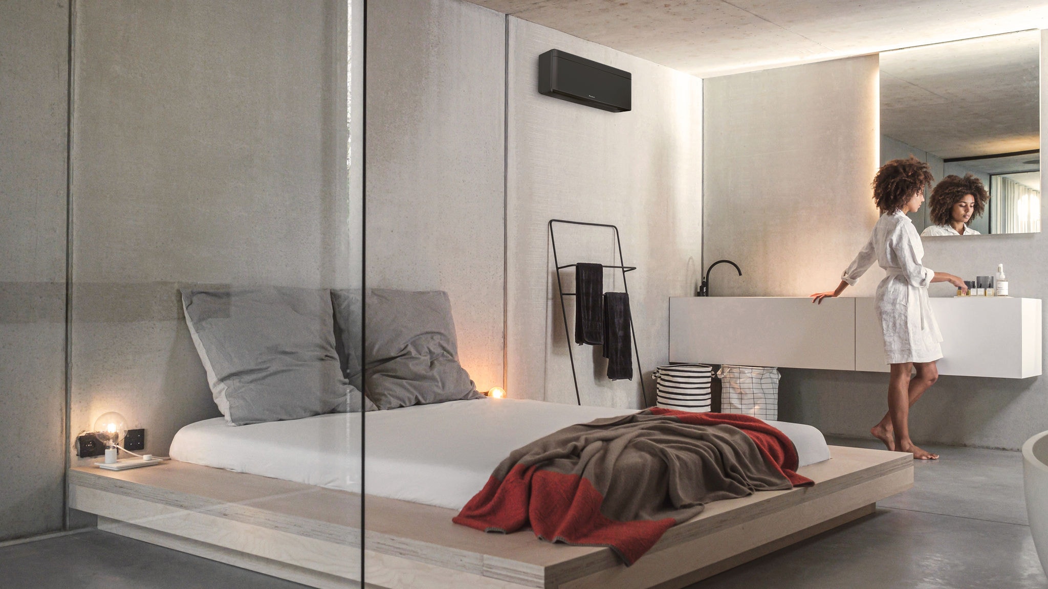En kvinna som gör sig klar för dagen i sitt sovrum och integrerade badrum, luftkonditionerade och uppvärmda av en Stylish inomhusenhet