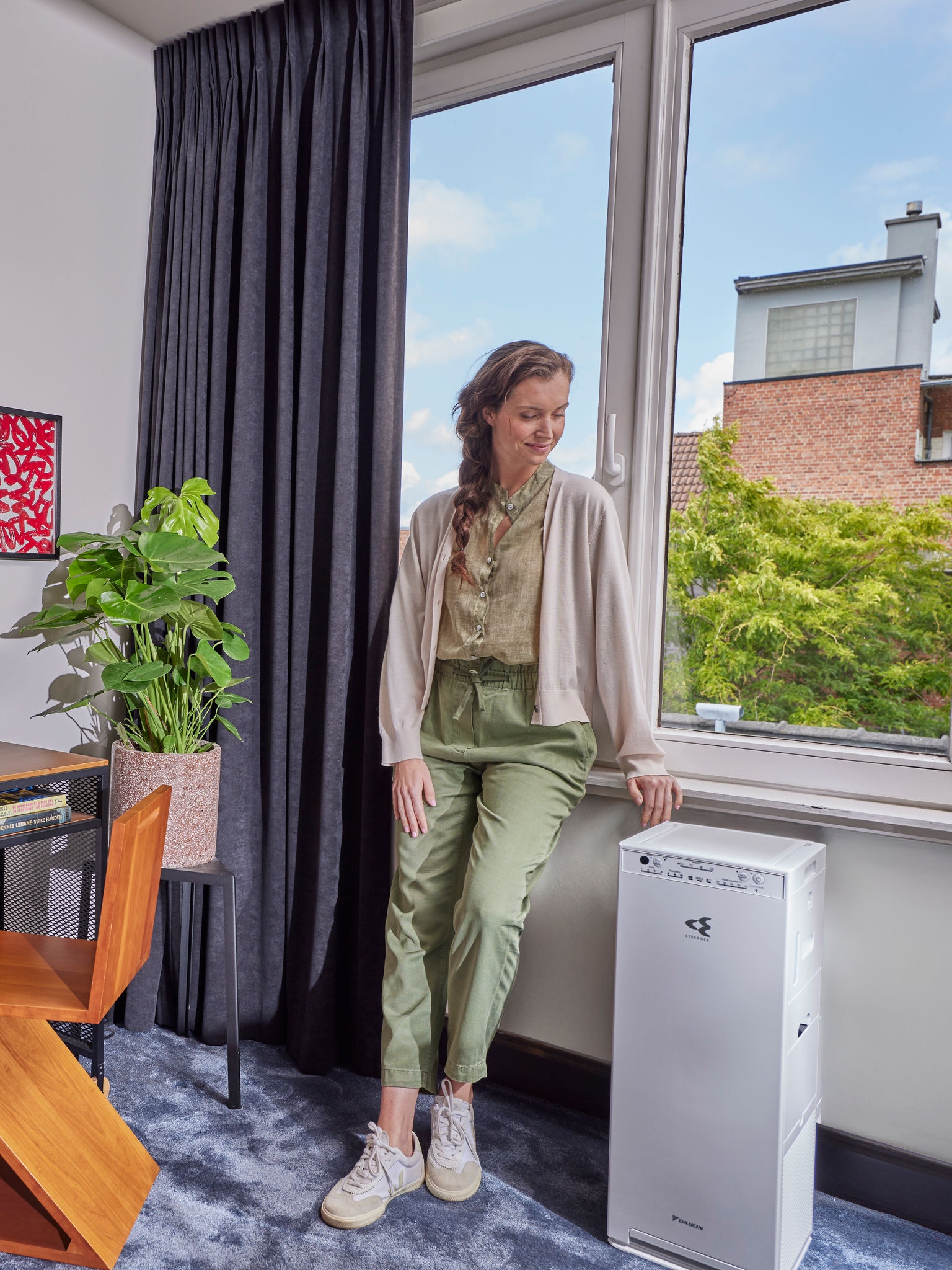 Kvinna som står bredvid sin luftrenare