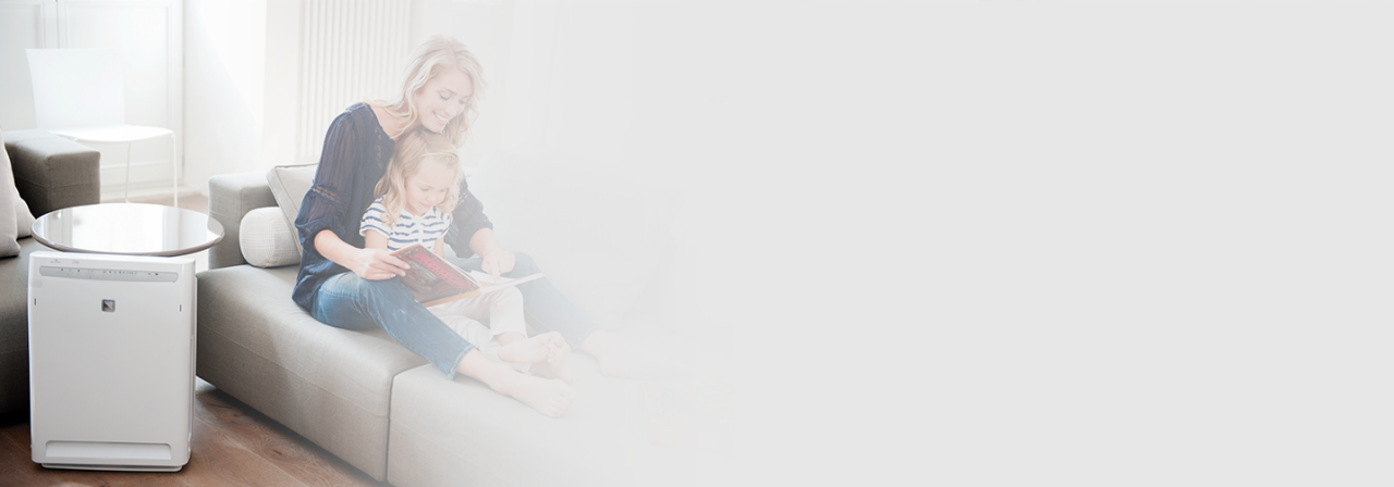 Mamma och dotter läser på en soffa